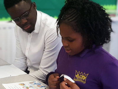 A volunteer from Sanctuary Housing reads with a pupil at Kingsmead Primary School